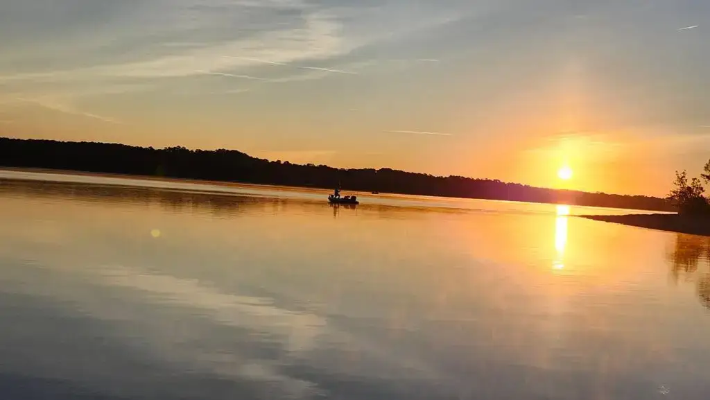 Fishing boat on the lake on an autumn sunrise